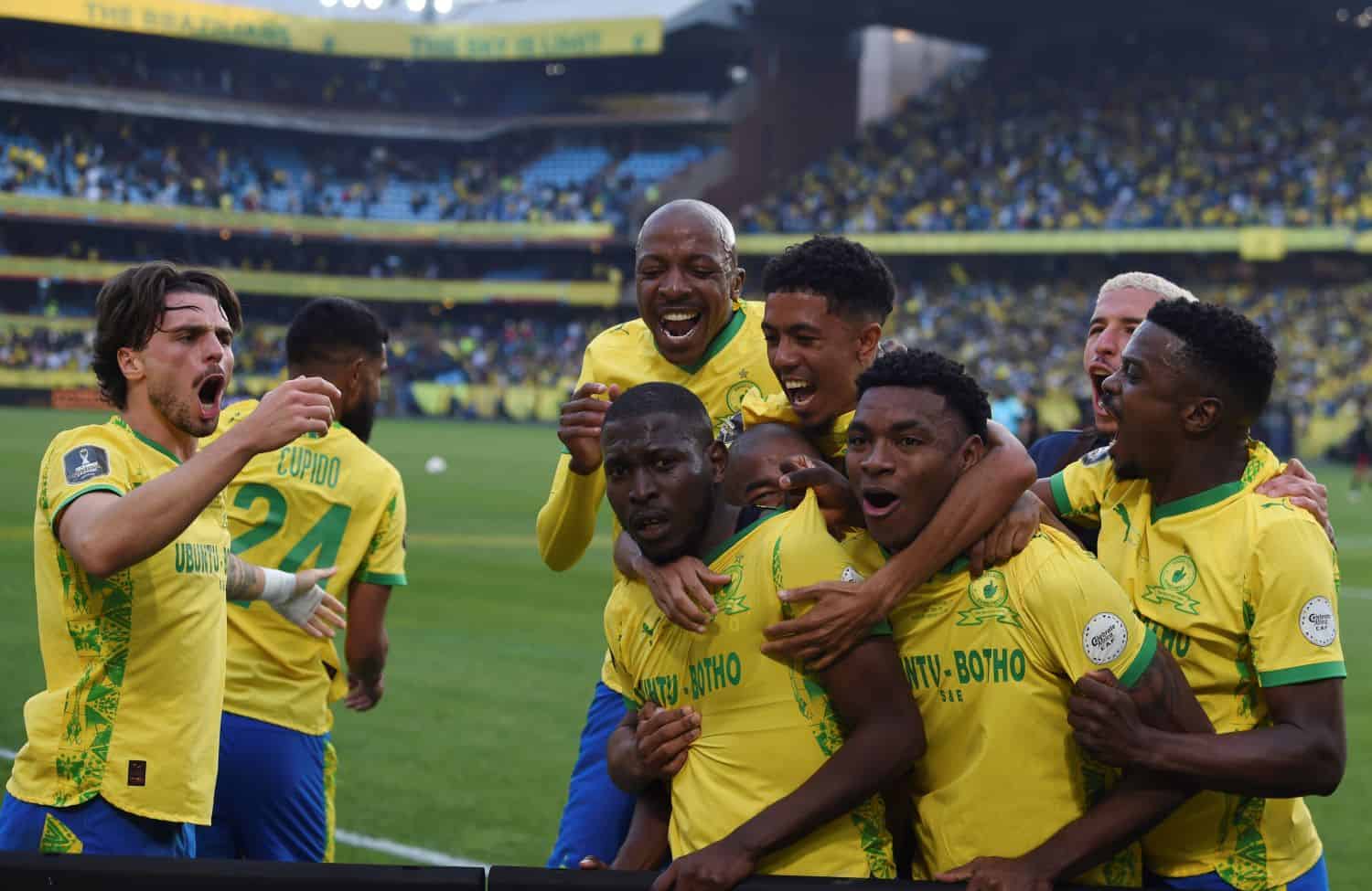 Mamelodi Sundowns players celebrating together in front of a full stadium